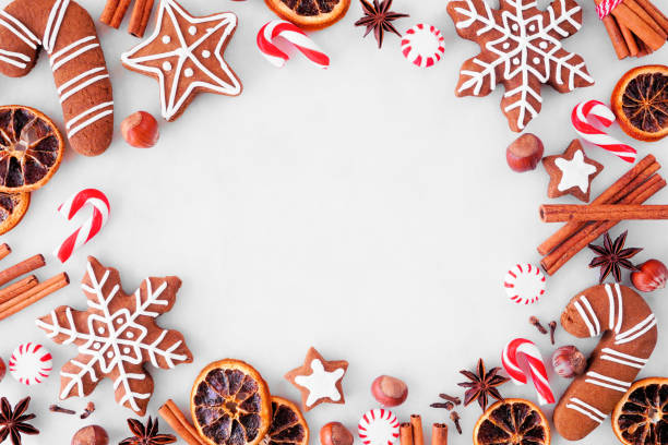 istock Christmas baking frame with cookies, peppermints and spices over a white marble background 1353245642