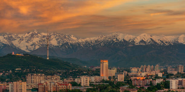 la ciudad de almaty y la cordillera zailiyskiy alatau al atardecer bajo un cielo expresivo - many glacier hotel fotografías e imágenes de stock