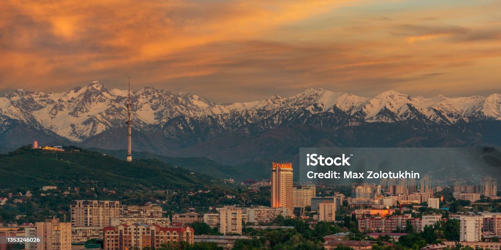 Almaty city and the Zailiyskiy Alatau mountain range at sunset under an expressive sky Kazakhstan Stock Photo