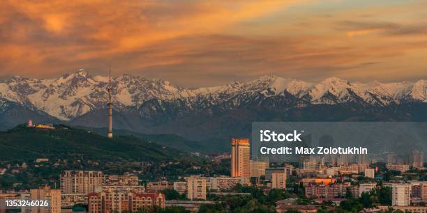 Almaty City And The Zailiyskiy Alatau Mountain Range At Sunset Under An Expressive Sky Stock Photo - Download Image Now