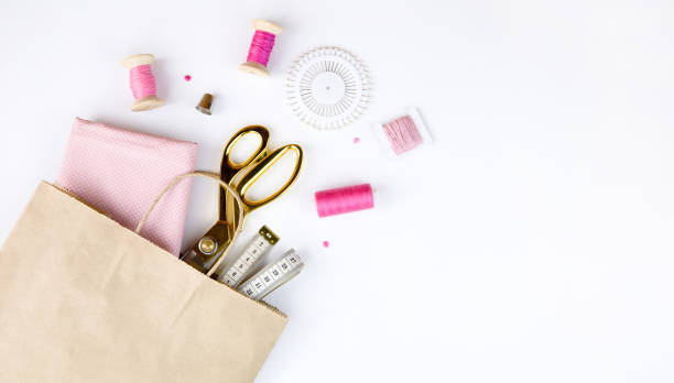 istock Scissors, thread, needles and cotton fabric in a craft bag. 1353247049
