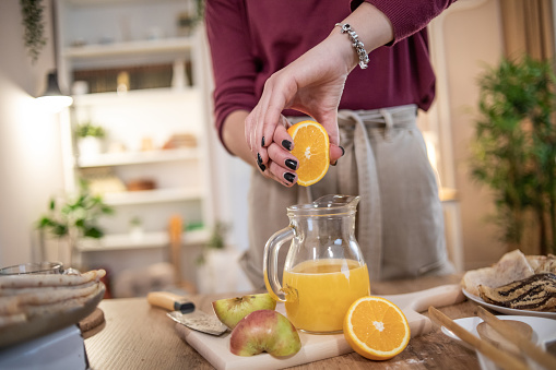One young woman, a young woman squeezes fruit and makes a healthy drink to start the day.