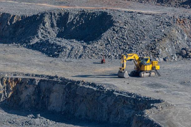 istock Yellow hydraulic excavator with crawler wheels in the mine with grey background 1353253373