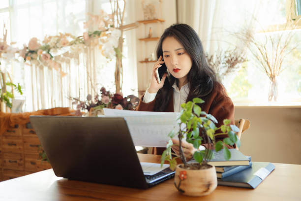 istock Young businesswomen chat on their mobile phones while working 1353254232