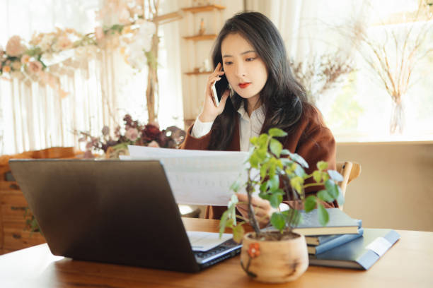 istock Young businesswomen chat on their mobile phones while working 1353254234