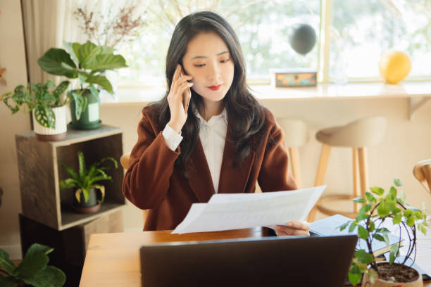 istock Young businesswomen chat on their mobile phones while working 1353254249