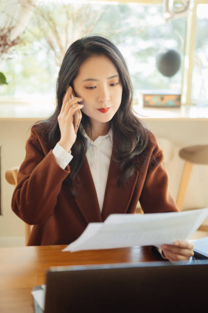 istock Young businesswomen chat on their mobile phones while working 1353255512
