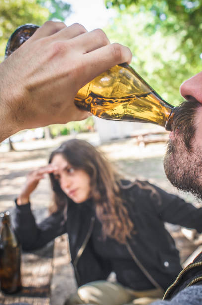 istock Couple chugging bottle beer. Express drinking and fast get drunk 1353260706