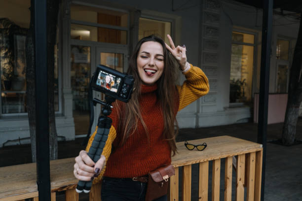 istock Content creator, blogger, vlogger young woman taking selfies, filming herself and having fun on city street. 1353261083