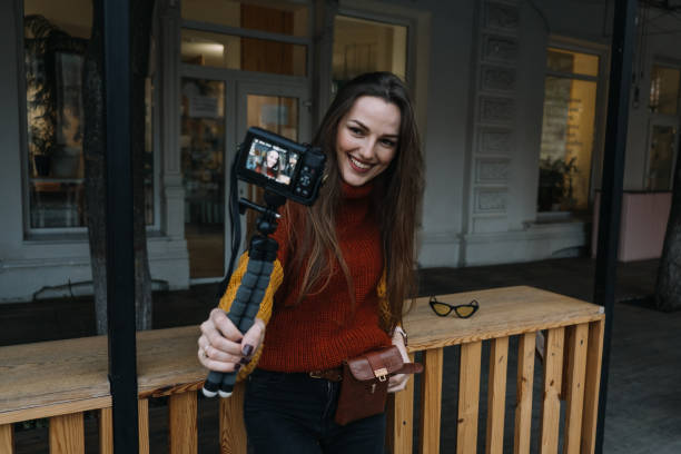 istock Content creator, blogger, vlogger young woman taking selfies, filming herself and having fun on city street. 1353261085