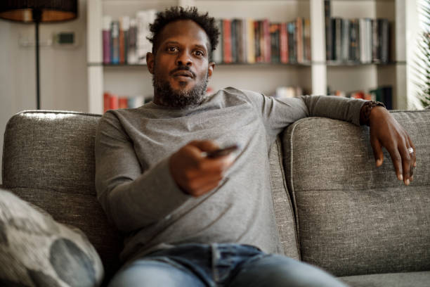 istock Man watching tv at home 1353265988