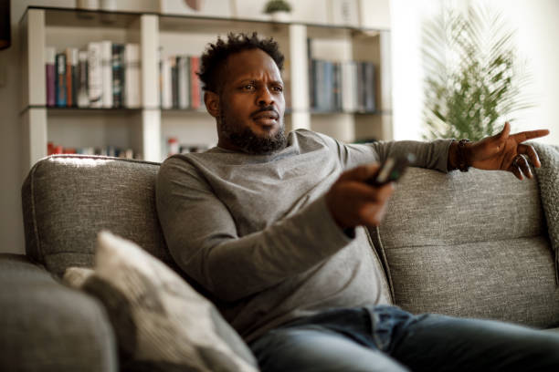 istock Angry man watching tv at home 1353266030