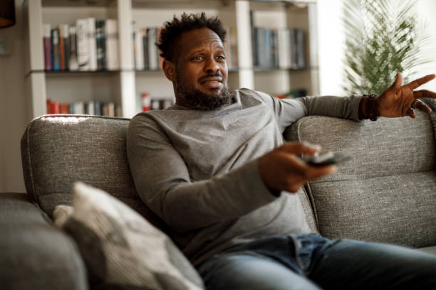 istock Disappointed man watching tv at home 1353266056