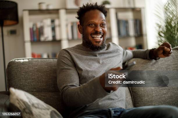 Excited Man Cheering While Watching Tv At Home Stock Photo - Download Image Now - Television Set, Television Industry, Watching TV