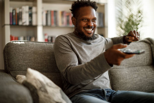 istock Excited man cheering while watching tv at home 1353266069