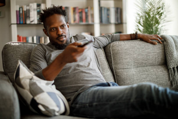 istock Man watching tv at home 1353266116