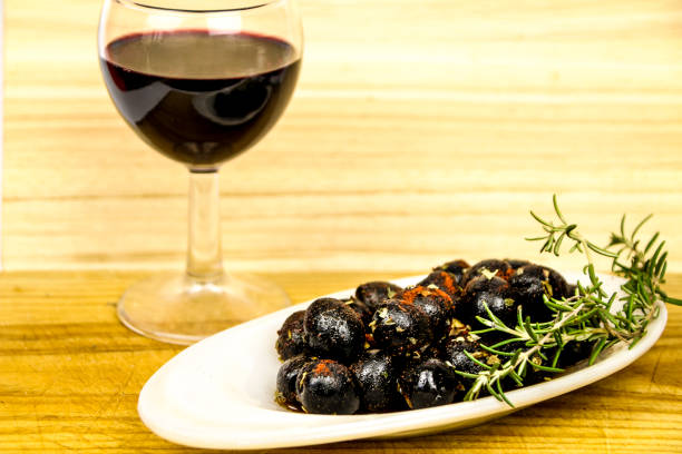 schwarze oliven gewürzt mit paprika, olivenöl und oregano - pepper spice dried plant image stock-fotos und bilder