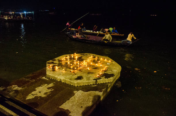 dev diwali festival celebration at varanasi 14th november 2016 varanasi india :Ghats of Varanasi decorated and light up with small earthen lamps during Dev Diwali Festival at the ghats of Ganges in Varanasi.Dev Diwali festival of Kartik Purnima has been decorated with lamps at Ganga Ghat in Varanasi. Swastika sign is made with earthen lamp. Tourists are observing this magnificent beauty in a tourist boat on the Ganges flowing in the background. Dev Diwali stock pictures, royalty-free photos & images