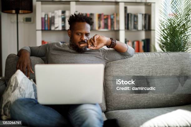 Young Man Watching Movie On Laptop At Home Stock Photo - Download Image Now - Confusion, Men, Laptop