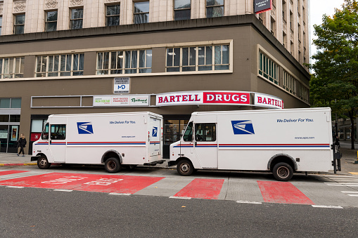 Seattle, USA - Oct 18, 2021: Late in the day UPS delivery trucks outside Bartell Drug in Westlake.