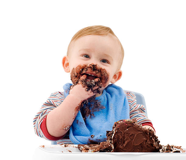 A messy baby eating his chocolate cake stock photo