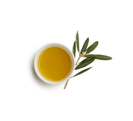 tazón de aceite de oliva con hoja de olivo photo
