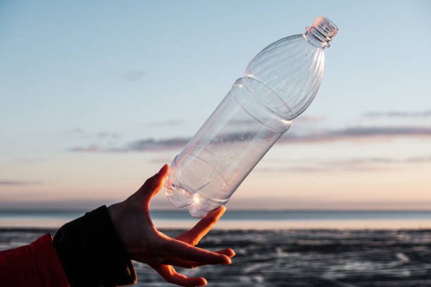 istock A human hand holds a plastic bottle thrown on the shore 1353274311