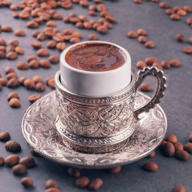 turkish coffee and turkish delight with a traditional embossed metal tray and cup. traditional coffee concept.  traditional turkish coffee on dark coffee beans background. - türk kahvesi stok fotoğraflar ve resimler