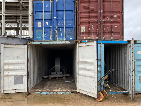 Multi-colored iron industrial sea containers for international transportation of goods according to the logistic rules of Incoterms 2010 DAP and DDP