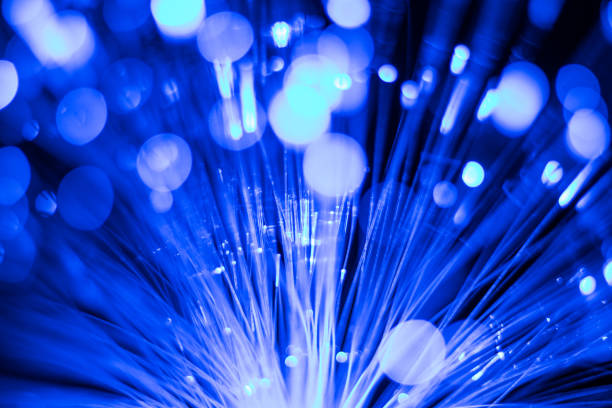 istock Luminous fiber optic light guides, dots and lines. Selective focus. Blue blurred abstract background. 1353278424