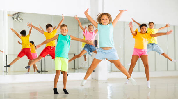 istock Group of cheerful tweens jumping during dances class 1353280451