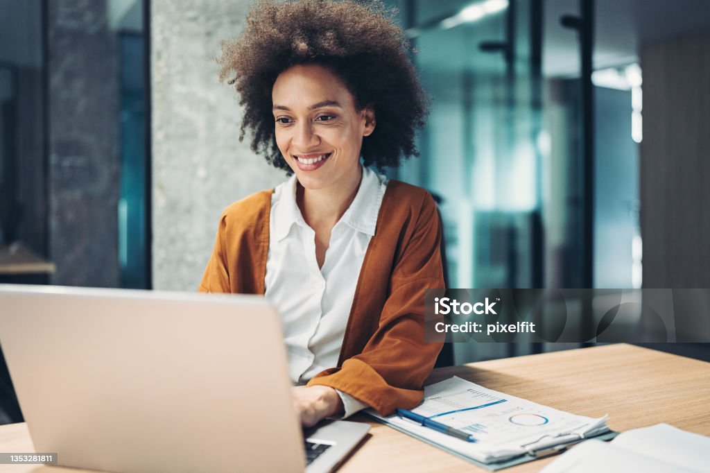 Businesswoman using laptop African ethnicity businesswoman working in her office Women Stock Photo