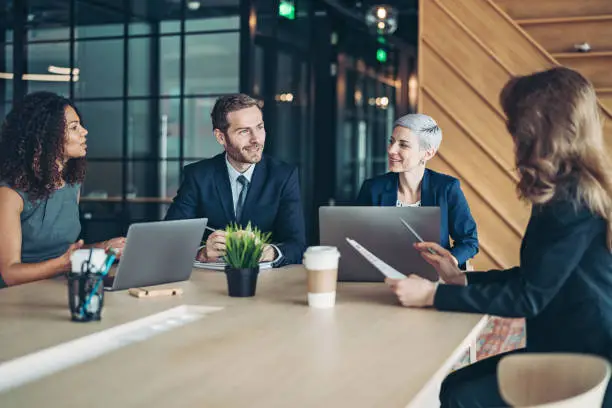 Group of business persons sitting around a table and talking