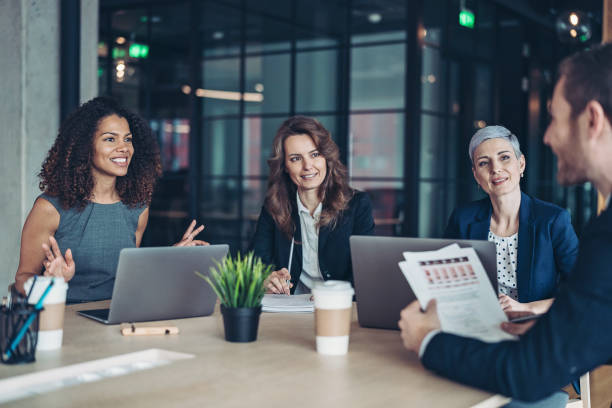 Group of businesswomen during a meeting Group of business persons sitting around a table and talking recruitment team stock pictures, royalty-free photos & images