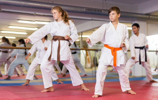 niños adolescentes con uniforme de karate posan - karate child judo belt fotografías e imágenes de stock