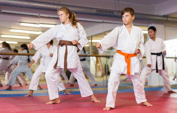 crianças adolescentes usando uniforme de karatê posam - karate child judo belt - fotografias e filmes do acervo