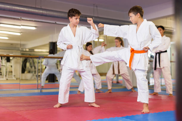 istock Kids in kimonos exercising techniques in pair during taekwondo class at gym closeup 1353281901