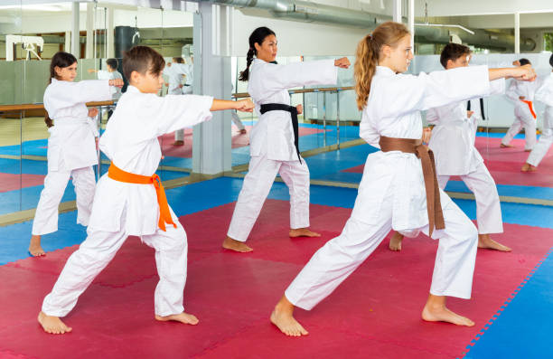 meninos e meninas exercitando kata durante o treinamento de karatê - karate child judo belt - fotografias e filmes do acervo