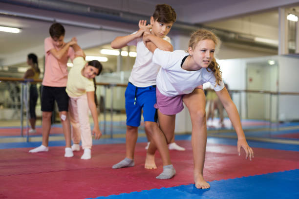 istock Young boys and girls on group self-protection training 1353282247