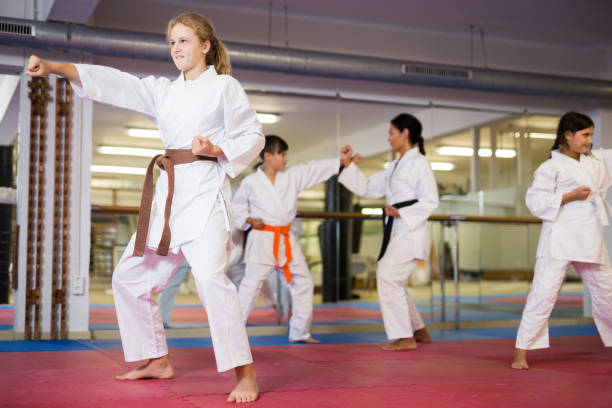 istock Serious girl practicing taekwondo movements in gym 1353282278