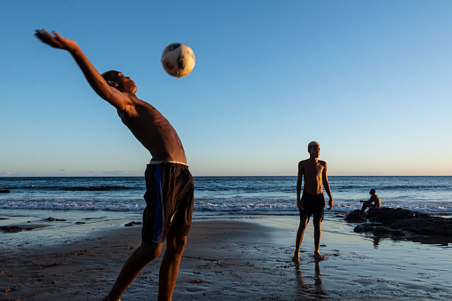 Salvador, Bahia, Brazil - January 08, 2020: Young people playing sand football at sunset on Ondina beach in Salvador, Bahia, Brazil.