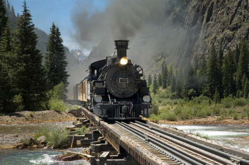 Narrow gauge steam powered train crosses the Animus River on its way to Silverton from Durango, Colorado.