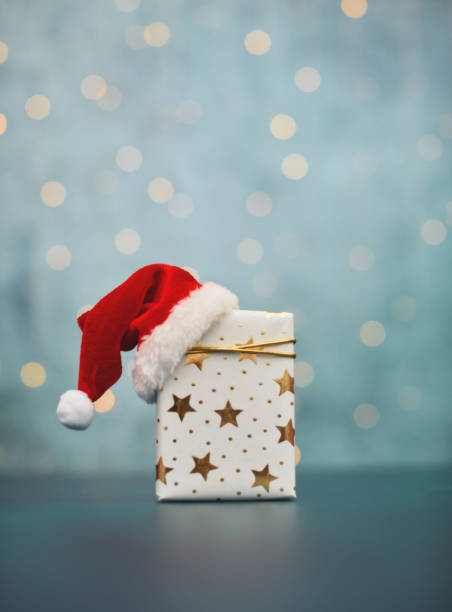 istock Teal Christmas Background with Christmas Gift and Santa Hat 1353284739