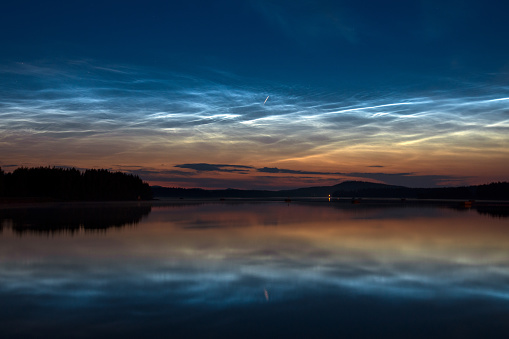 Noctilucent clouds and Perseid meteor at night sky