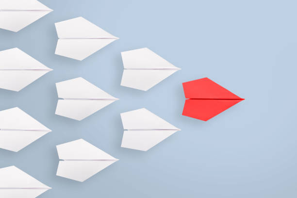 istock Leadership concepts with red paper airplane leading among white 1353289009