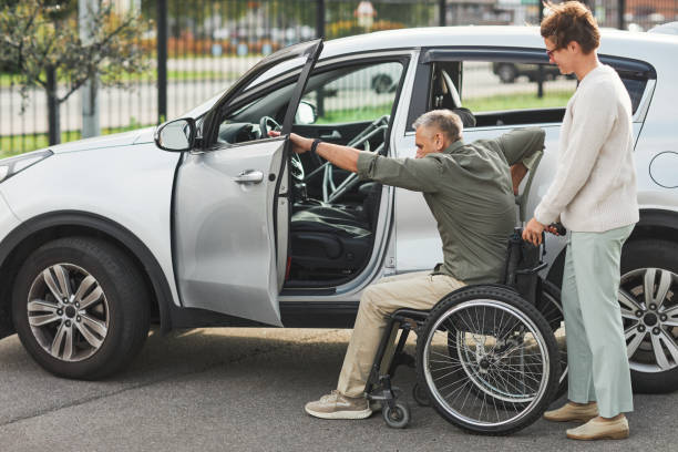 istock Man in Wheelchair Getting in Car 1353290875