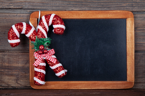 Blackboard Christmas decoration - Be Merry candy cane on rustic wooden background