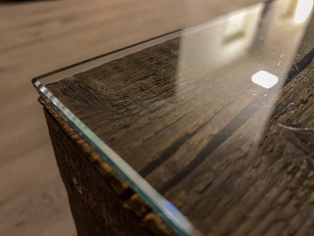 istock A table edge of a wooden table with glass top. 1353294079
