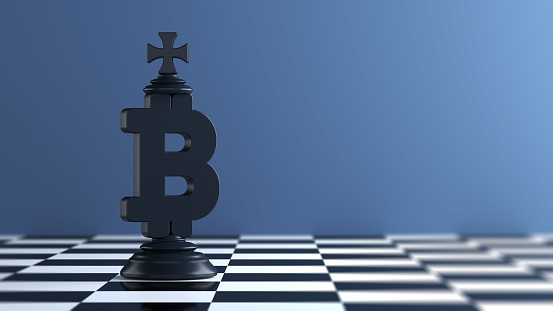 Black-colored king-chess piece-shaped Bitcoin symbol. On chessboard. Horizontal composition with copy space. Focused image