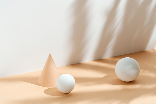 Geometric, sphere and cone objects on white and beige, cream background